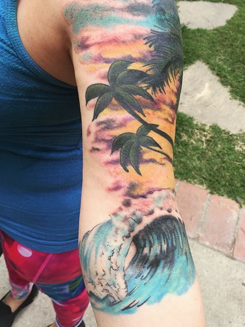 arm waves beach scene tattoo