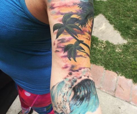 arm waves beach scene tattoo