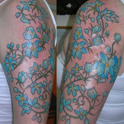 blue flowers arm tattoo