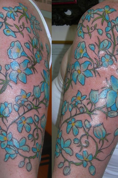 blue flowers arm tattoo