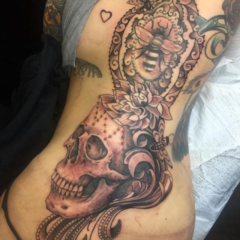 skull and bee rib tattoo