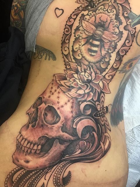 skull and bee rib tattoo
