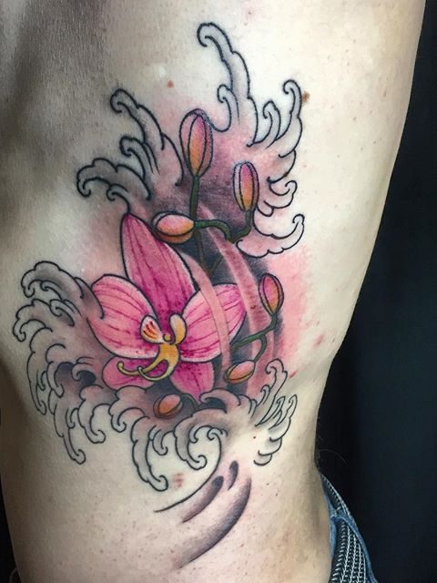 flowers and waves rib tattoo